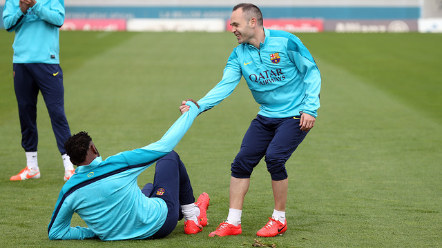 Andrés Iniesta ajudant Alex Song a aixecar-se.